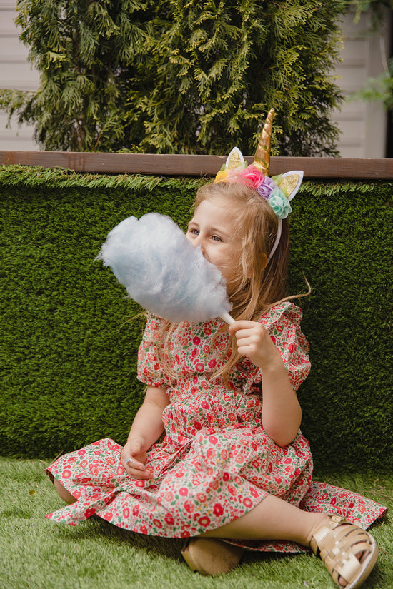 Young girl eating fairy floss at kids party